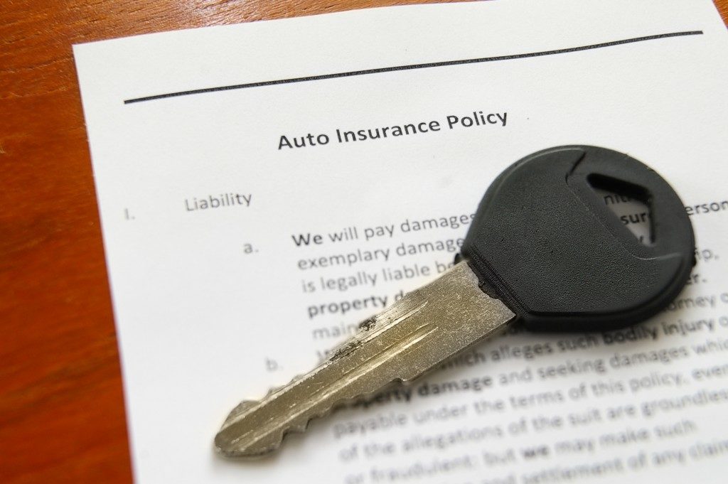 Closeup of a car key on an auto insurance policy
