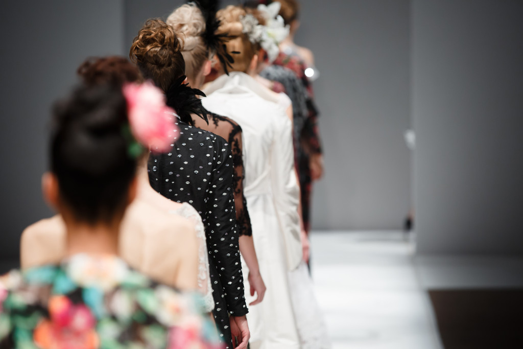rows of women in beautiful clothes in a fashion show
